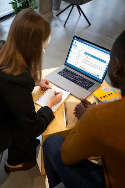 two-people-working-on-laptop-and-taking-notes