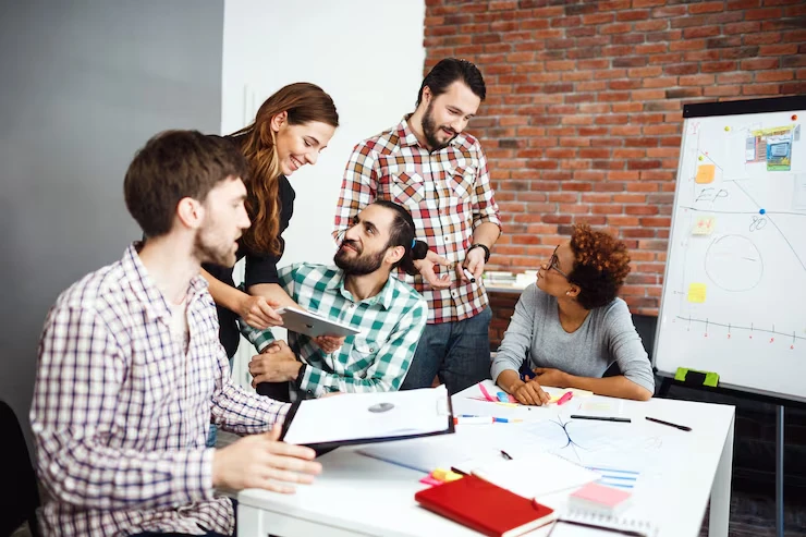 Five professionals planning website linking structure strategy around whiteboard and documents in modern office
