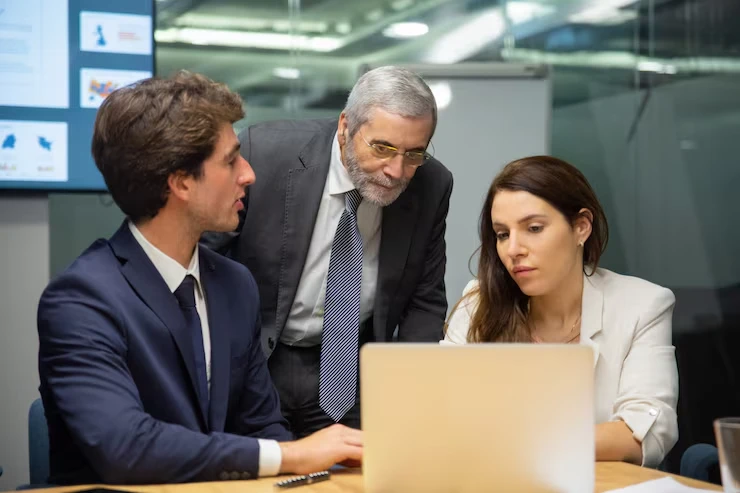 Three business professionals strategizing local SEO optimization for UK businesses in modern corporate office