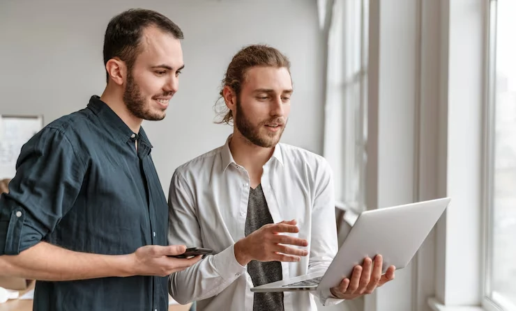 Two content SEO specialists reviewing content production strategy on tablet for optimized digital marketing