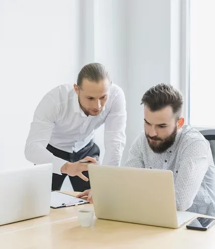Two ecommerce SEO specialists analyzing website performance data on laptop for online store optimization