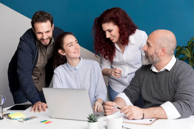 Four professionals collaborating on schema markup structured data strategy around laptop in modern office