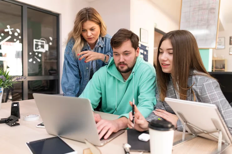 Young professionals conducting technical SEO audit analysis on laptop in modern collaborative workspace