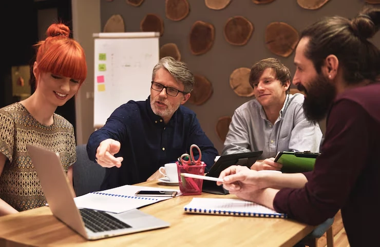 UK agency team discussing white label guest post services strategy in collaborative meeting with laptops and notes