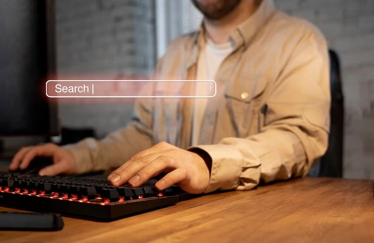 A man types on a keyboard in an office setting, showing the work environment of a Digital Marketing Agency in Italy.