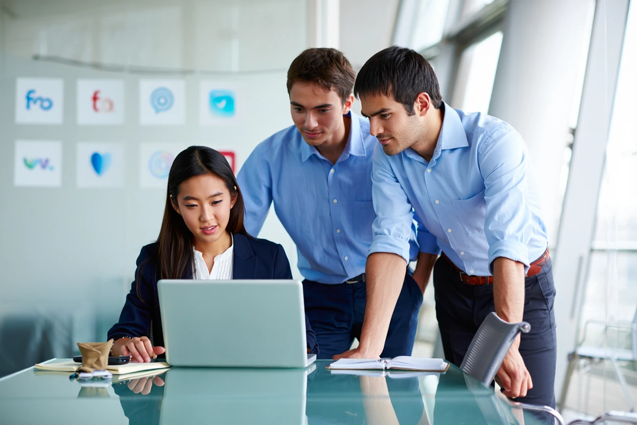 Marketing team reviewing influencer outreach campaigns and partnership strategies on laptop with brand logos displayed