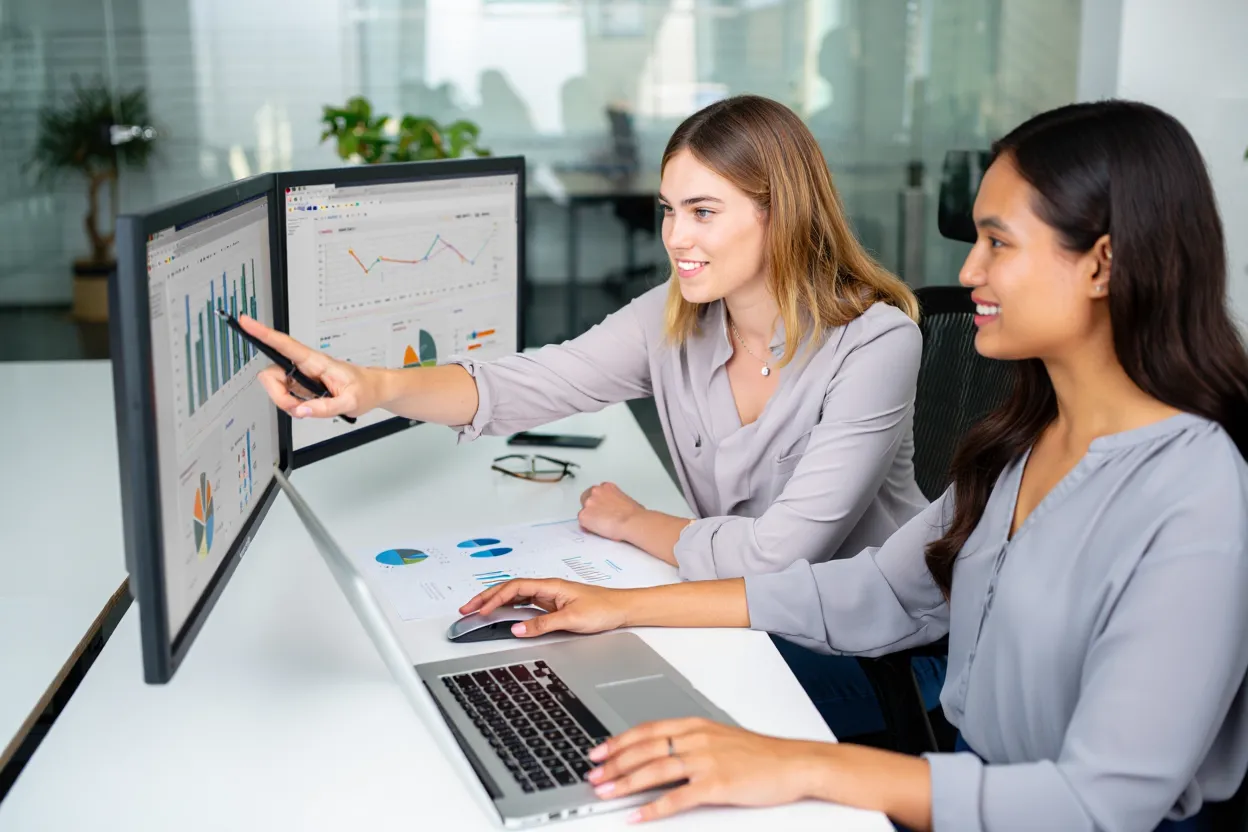 Two analysts reviewing digital PR performance metrics and growth charts on large monitor