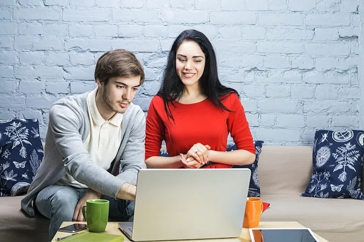 Couple reviewing data and statistics on laptop