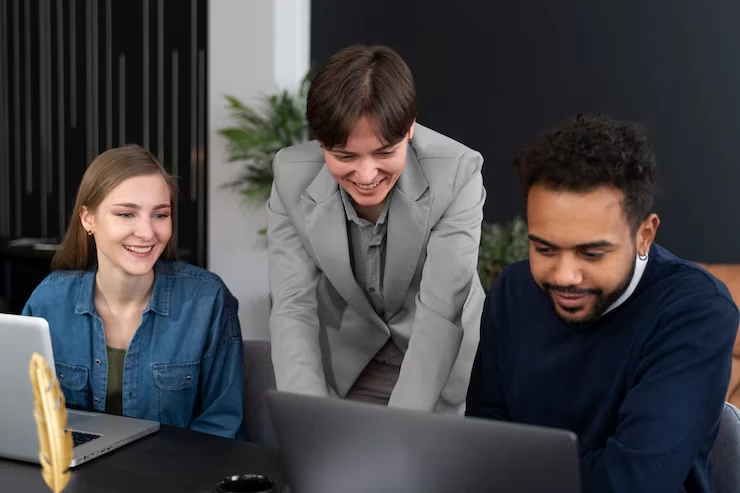 Three colleagues collaborating on laptops