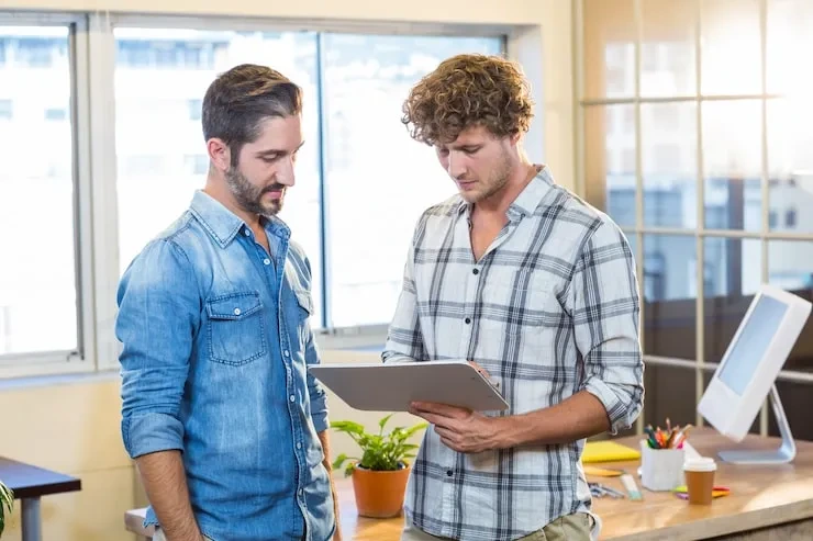 Two professionals reviewing tablet in office